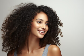 Woman with curly hair is smiling and looking at camera