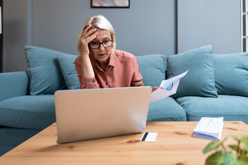 Shocked concerned senior accountant woman finding financial failure, mistake, bankruptcy, sitting...