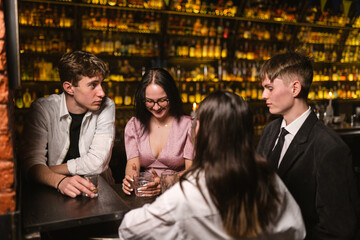 Young colleagues celebrate weekend beginning with cocktails in pub. Employees team spends time...