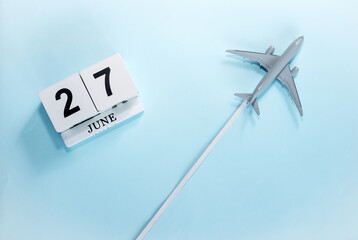 June calendar with number  27. Top view of a calendar with a flying passenger plane. Scheduler....