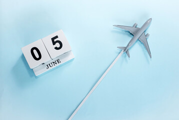 June calendar with number  5. Top view of a calendar with a flying passenger plane. Scheduler. Travel concept. Copy space.