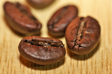 A closeup photo of coffee beans on wooden background