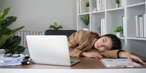 Asian businesswoman feeling tired and stressed over an unsuccessful business while working in a...