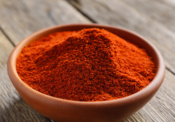 Paprika in a bowl on wooden table