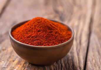 Paprika in a bowl on wooden table