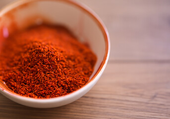 Paprika in a bowl on wooden table