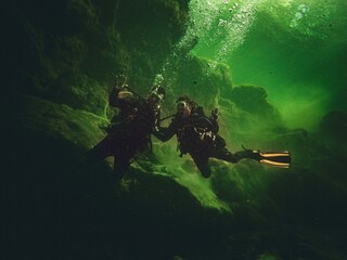 A local married couple scuba dives together in the greenish waters of Troy Springs State Park,...
