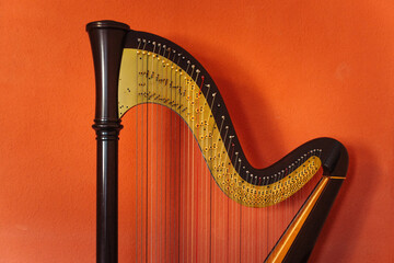 Harp isolated on orange background. Wooden musical instrument.
