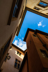 Fototapeta na wymiar Vue vers le ciel, entourée d’immeubles anciens typiques, depuis une ruelle du Vieux Lyon