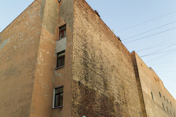 A brick building with a window on the side. The building is brown and has a lot of bricks