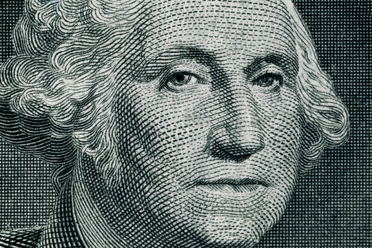 George Washington's face on a one dollar bill. United States national currency banknote fragment. George Washington portrait