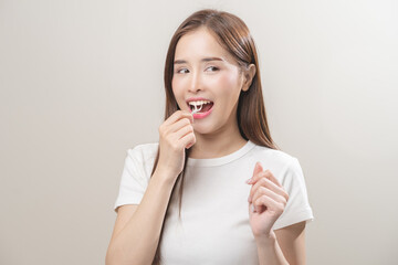 Flossing teeth, dental care hygiene, asian young woman flossing teeth with dental floss pick, smile happy with perfect white teeth, using tooth floss cleaning, healthy teeth isolated on background.