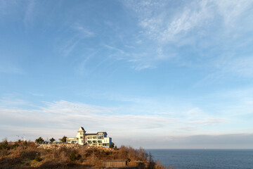 View of the white building on the cliff at the seaside