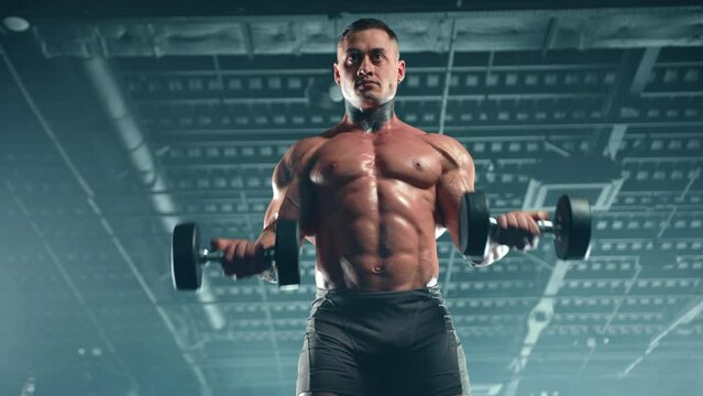 Focused bodybuilder intensely working out with dumbbells in the gym, every rep showcasing his commitment to building muscle and strength. Camera 8K RAW. 
