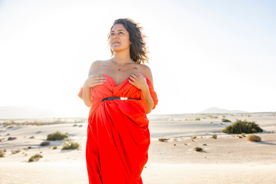 Woman in Red Embracing the Desert Landscape