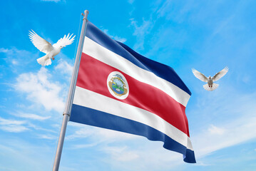 Waving flag of Costa Rica in beautiful sky and flying pigeons. Costa Rica flag for independence day. The symbol of the state on wavy fabric.