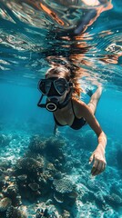 side view of calm unrecognizable female diver in diving goggles swimming underwater near coral reefs while relaxing on summer vacation