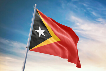 Waving flag of East Timor in blue sky. East Timor flag for independence day. The symbol of the state on wavy fabric.