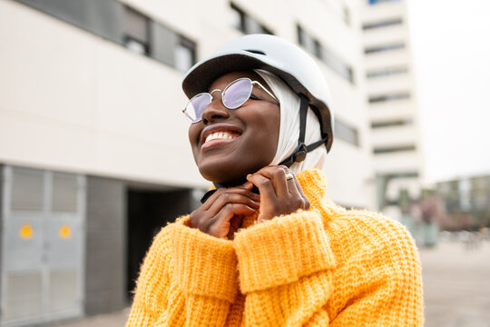 Joyful urban woman with bicycle helmet