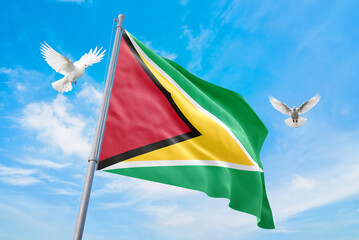 Waving flag of Guyana in beautiful sky and flying pigeons. Guyana flag for independence day. The symbol of the state on wavy fabric.