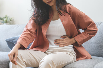 Flatulence ulcer, asian young woman, girl hands in belly, stomach pain from food poisoning, abdominal pain and digestive problem, gastritis or diarrhea. Abdomen inflammation, menstrual period people. - obrazy, fototapety, plakaty