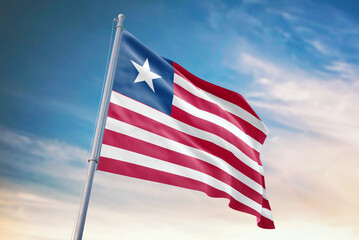 Waving flag of Liberia in blue sky. Liberia flag for independence day. The symbol of the state on wavy fabric.