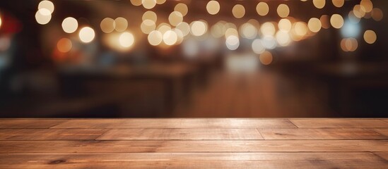 A beautiful brown hardwood plank table with wood stain and varnish, set against a blurry background of amber lights. The flooring adds to the warm tints and shades of the scene - obrazy, fototapety, plakaty