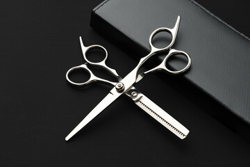 Hairdressing scissors with case on a black background