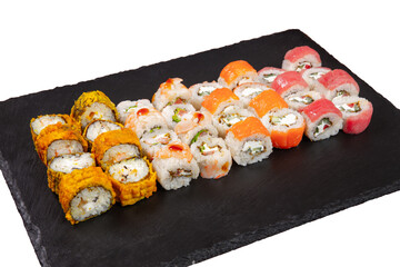 Sushi set served on black stone tray. Various types of sushi rolls served on a slate slab. Isolated on white.
