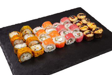 Sushi set served on black stone tray. Various types of sushi rolls served on a slate slab. Isolated on white.