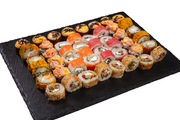 Sushi set served on black stone tray. Various types of sushi rolls served on a slate slab. Isolated on white.
