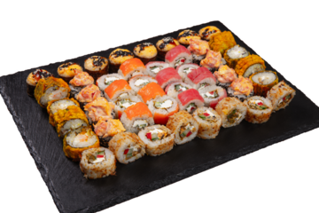 Sushi set served on black stone tray. Various types of sushi rolls served on a slate slab. Isolated on white.