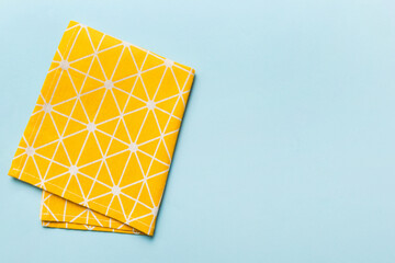 top view with yellow empty kitchen napkin isolated on table background. Folded cloth for mockup with copy space, Flat lay. Minimal style - obrazy, fototapety, plakaty