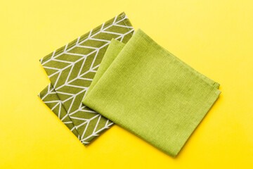 top view with green kitchen napkin isolated on table background. Folded cloth for mockup with copy space, Flat lay. Minimal style