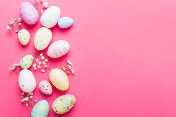 Happy Easter composition. Easter eggs on colored table with gypsophila. Natural dyed colorful eggs...