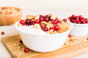 Healthy breakfast food with granola, yogurt, fruits and nuts. Dessert parfait with dried fruits for breakfast