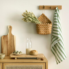 Interior design of kitchen space with rattan commode, cutting board, hanger, basket with dried...