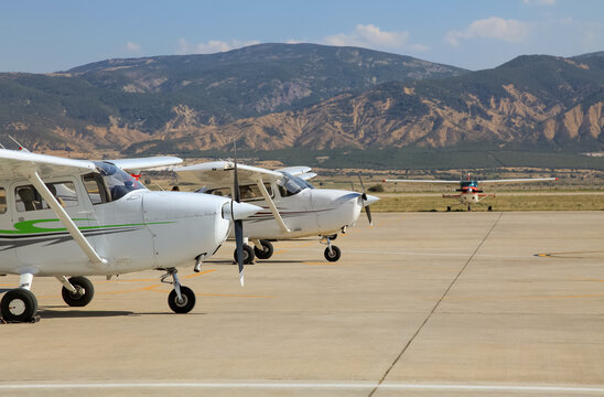Small single propeller planes parked at the airport.