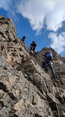 Climbers ascending a steep rocky slope