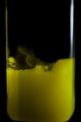 Olive oil bottle with natural sediment grounds in the bottom with black background