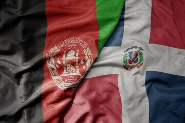 big waving national colorful flag of dominican republic and national flag of afghanistan.