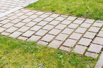 path lined with garden stones green lawn