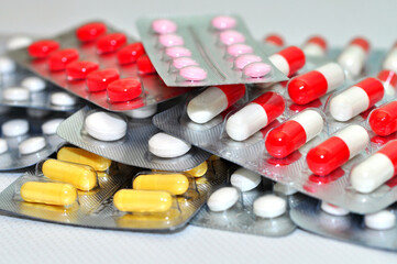 Colorful tablets and capsules in blisters close-up