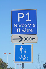Panneaux signalant le parking 1 du musée Narbo Via et du théâtre à 300 mètres et la voie réservée aux vélos et piétons.