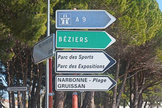 Panneau de signalisation indiquant les directions de : autoroute A9, Béziers, Hérault, parc des sports, parc des expositions, Narbonne plage, Gruissan, Aude, Languedoc, Occitanie, France.