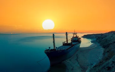 Foto op Canvas A ship washed ashore, photographed day and night © Samet