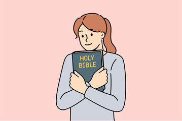 Believing woman embraces bible and feels enlightened after reading religious christian book with sermons or prayers. Holy bible in hands of teenage girl who wants to start study orthodoxy - obrazy, fototapety, plakaty