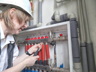 Female middle aged Technician Adjusting Industrial Water Filtration System. A woman services a...