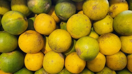 Close up pile of tasty fresh oranges sold at the market as a background.