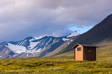 Small wooden hut in the middle of the Sarek National Park, Sweden. Summer landscape of Northern Europe wilderness with a cabin.